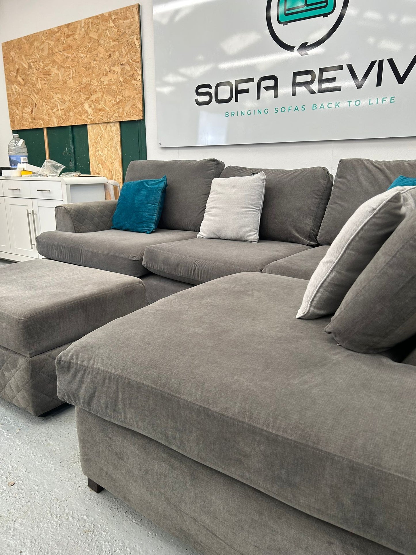Grey DFS Orka corner sofa with matching storage footstool